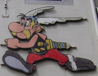 Eine Asterix-zeichnung außen an einer Hauswand. Die gezeichnete Figur hat blonde Haare und einen blonden Schnurrbart. Er trägt einen Helm mit Flügeln.