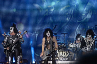 Die Band KISS auf der Bühne: Alle sind schwarz-weiß und maskenhaft geschminkt, sie spielen verschiedene Instrumente.