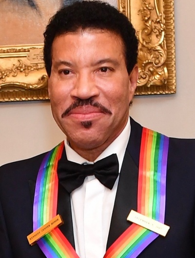 Lionel Richie in Anzug und Fliege. Dazu trägt er einen Orden an einem Regenbogefarbenen Band.