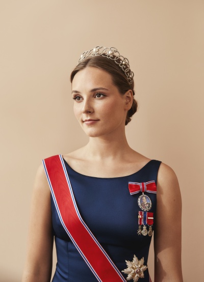 Prinzessin Ingrid Alexandra mit Diadem und einer roten Schärpe über ihrem dunkelblauen Kleid.