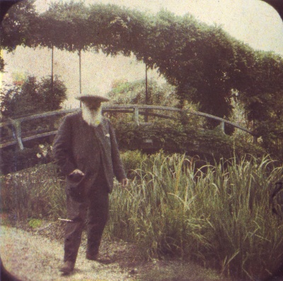 Ein Mann mit langen, weißem Bart steht in seinem Garten.