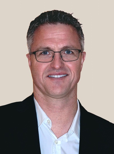 Ralf Schumacher mit kurzen Haaren und Brille. Er schaut leicht lächelnd in die Kamera.