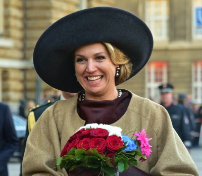 Máxima der Niederlande mit einem großen Hut und einem Blumenstrauß